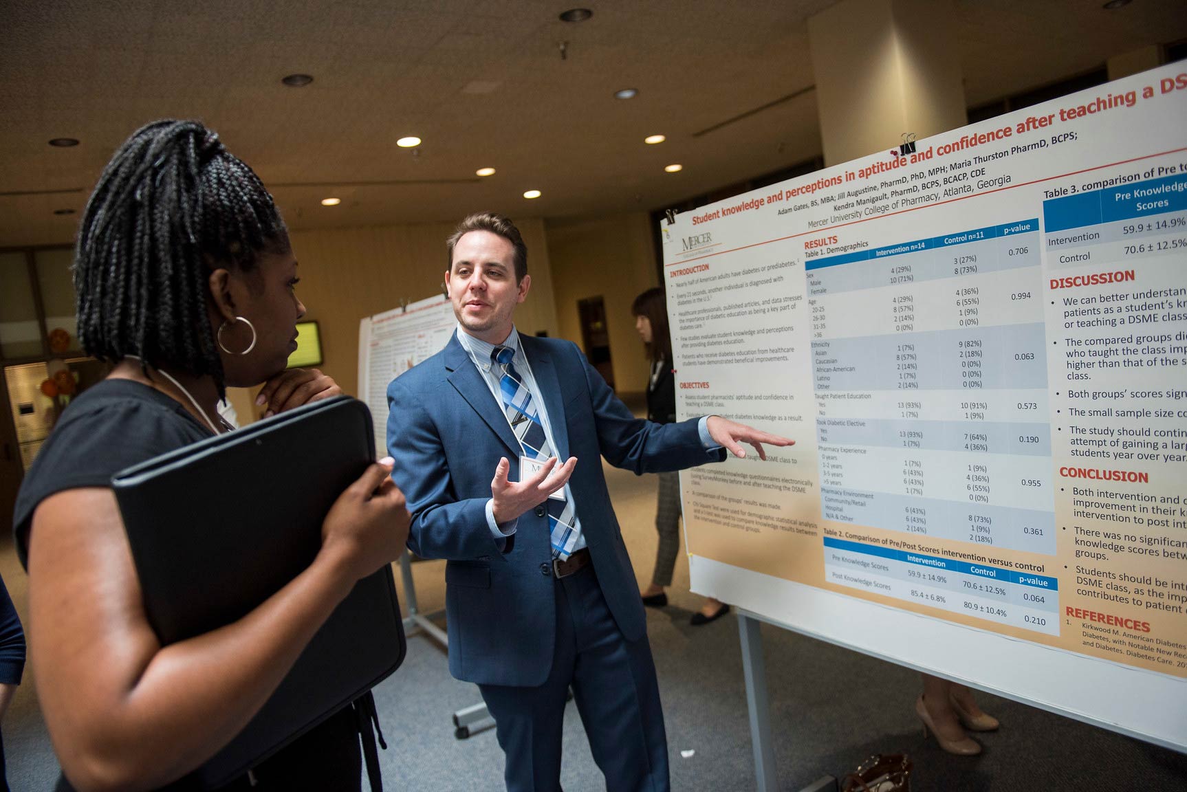 A woman listens looks at a poster being presented at the Atlanta Research Festival.