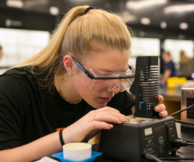A student uses science equipment in a lab.