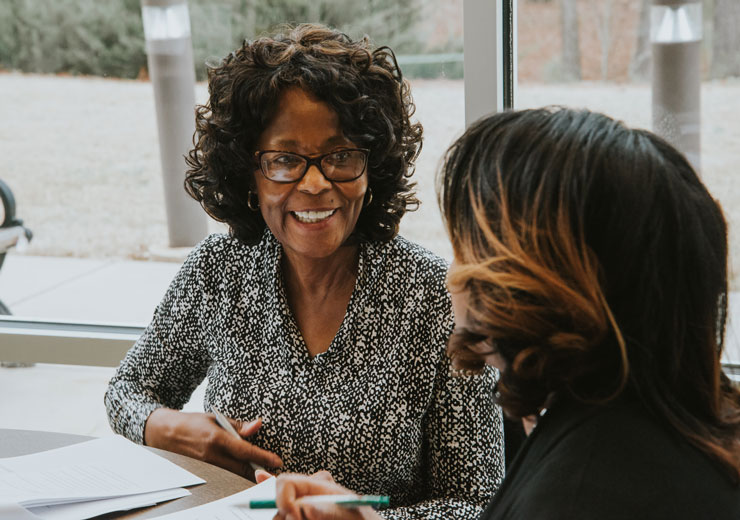 Professor and adult student working at table