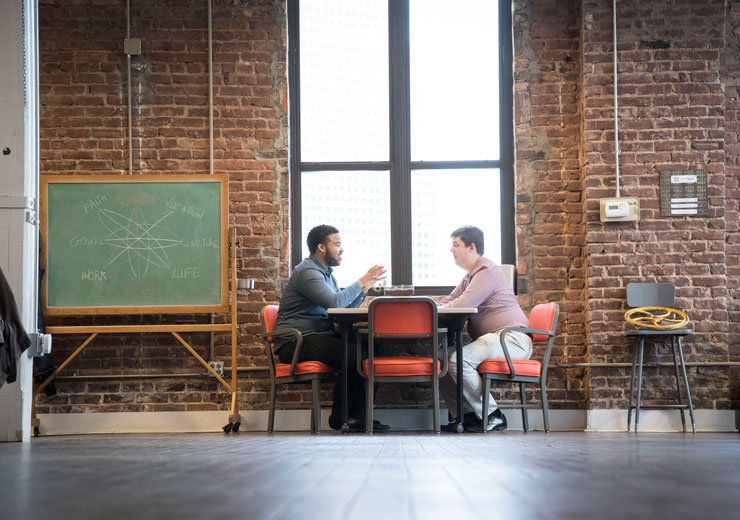 Theology student talking across table