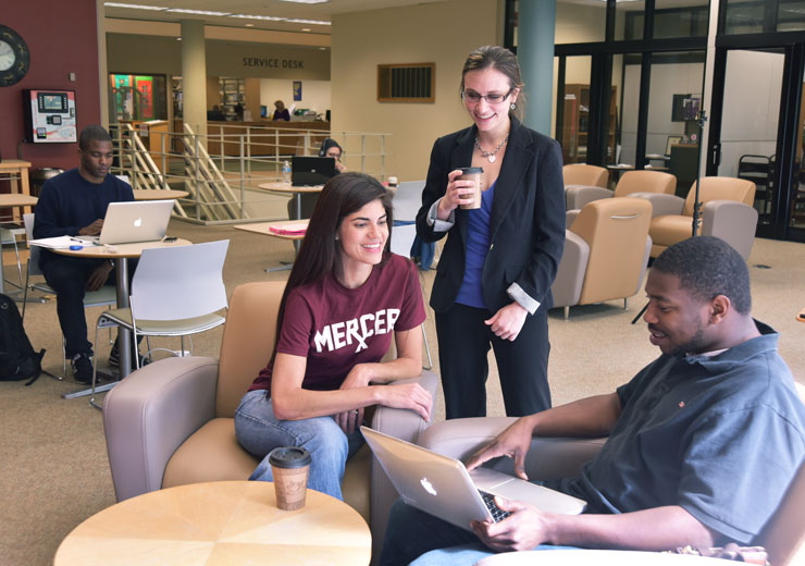 Three people talk inside the Monroe F. Swilley Jr. Library in Atlanta.