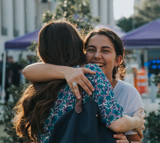 Students at MAC party hugging