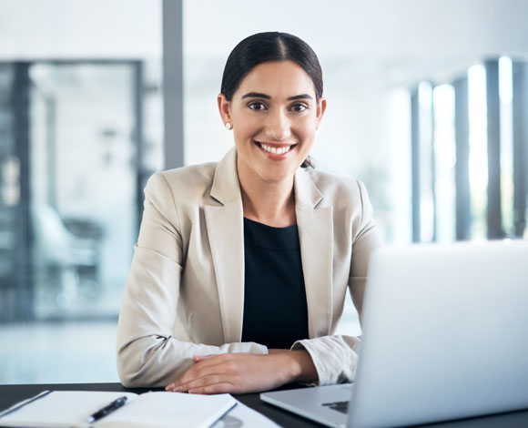 Adult student smiling behind laptop