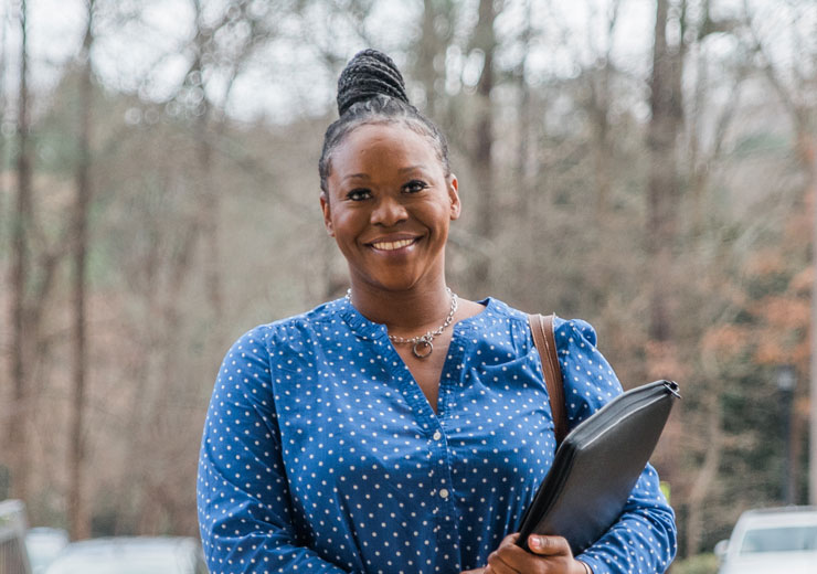 Smiling adult student holding portfolio