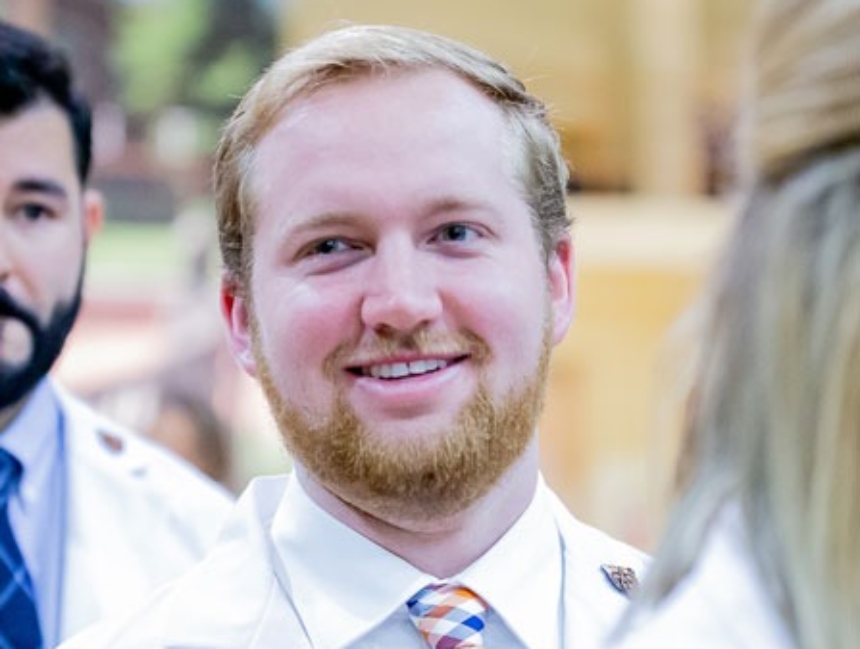 Smiling student in white lab coat