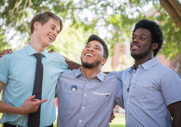 Three male students laugh on the Macon campus.