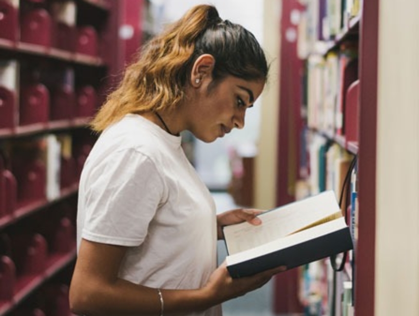 Student reading book in library