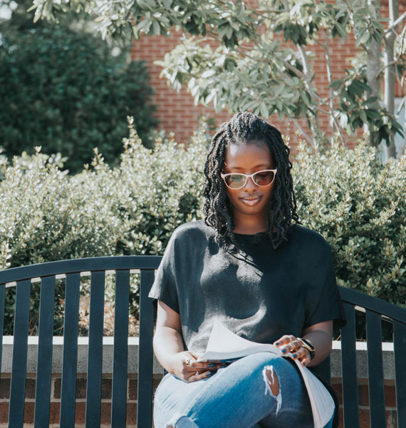 Student studying on outdoor bench