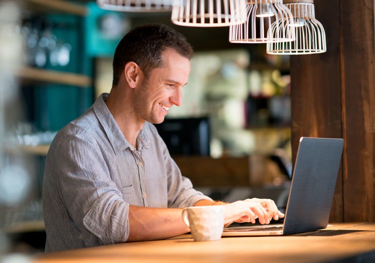 Smiling adult student working at laptop