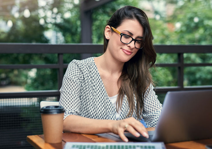 Aduly student with glasses typing on laptop