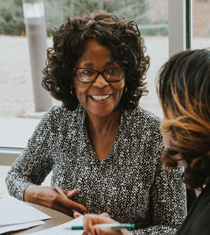 Professor and adult student working at table