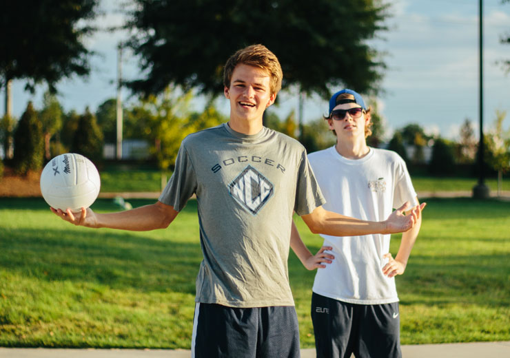 Guys playing beach volleyball recreationally