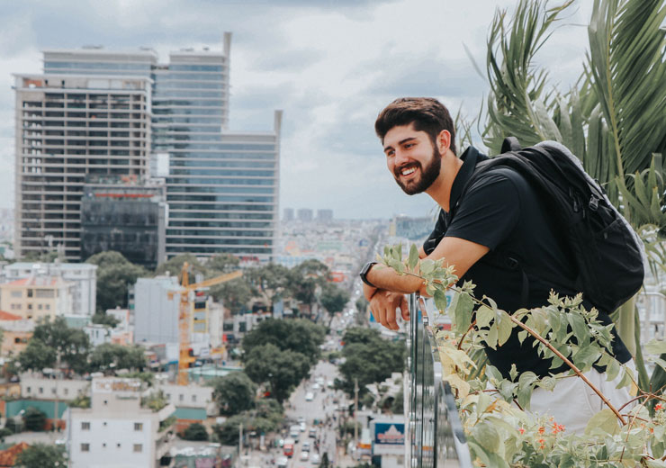 Student on balcony with city in background