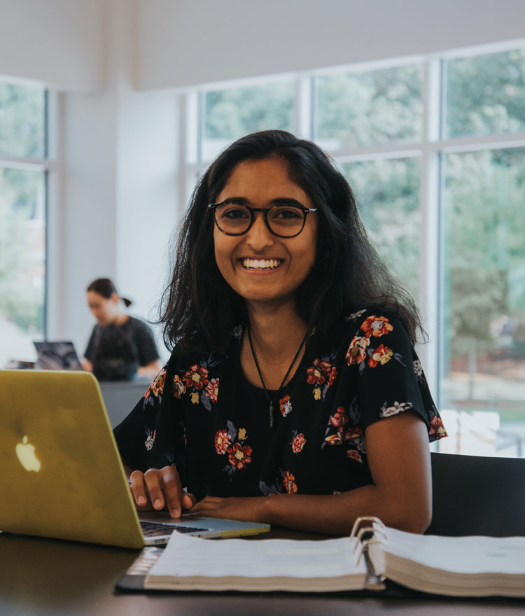 Shailey Shah smiles in lobby of Godsey Science Center