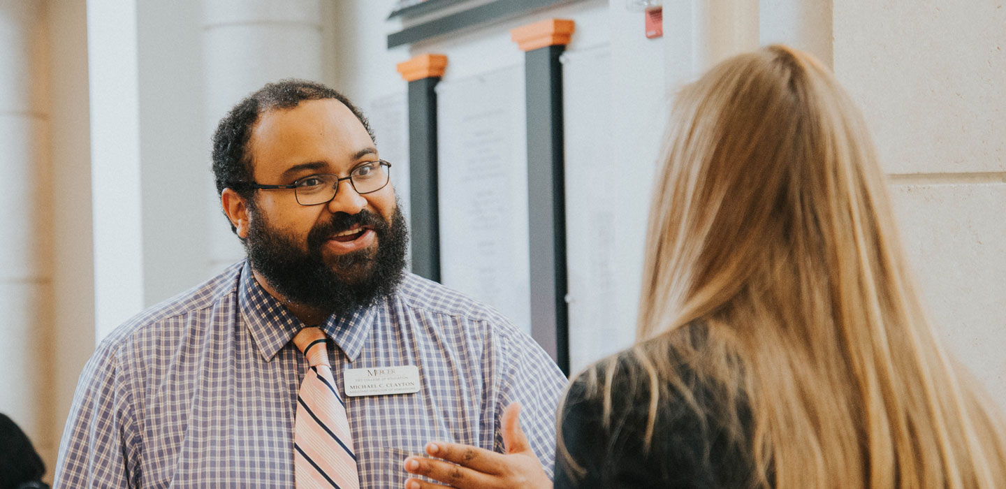 Michael Clayton speaking with student