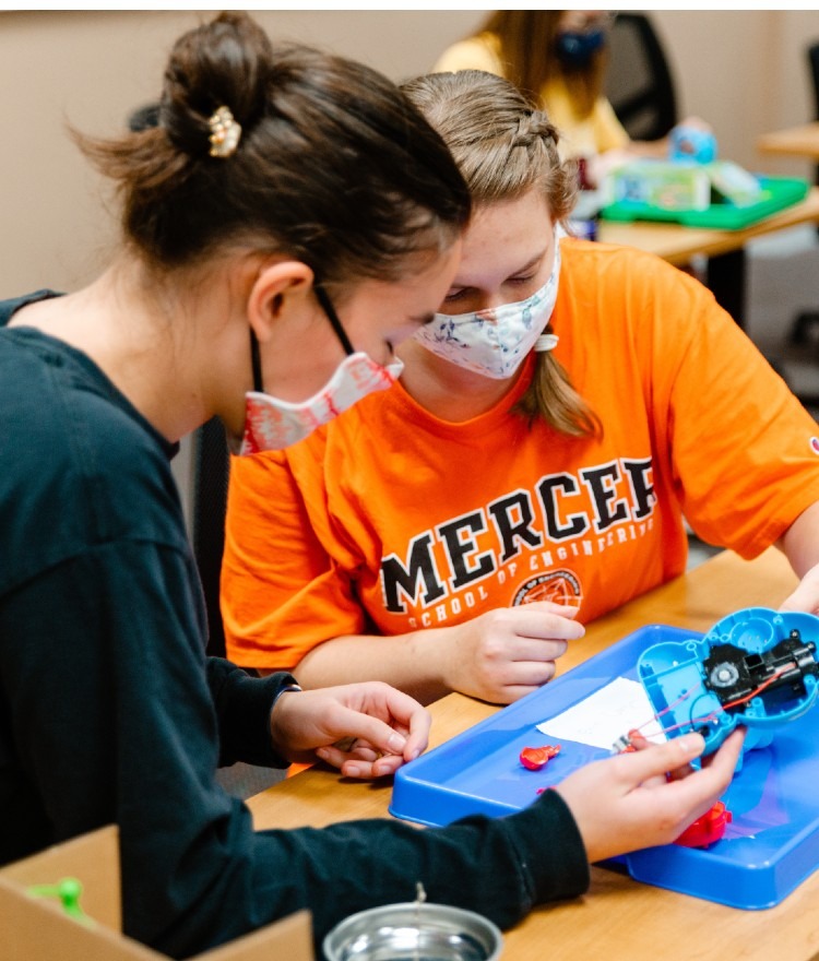 Two engineering students work on a bubble toy