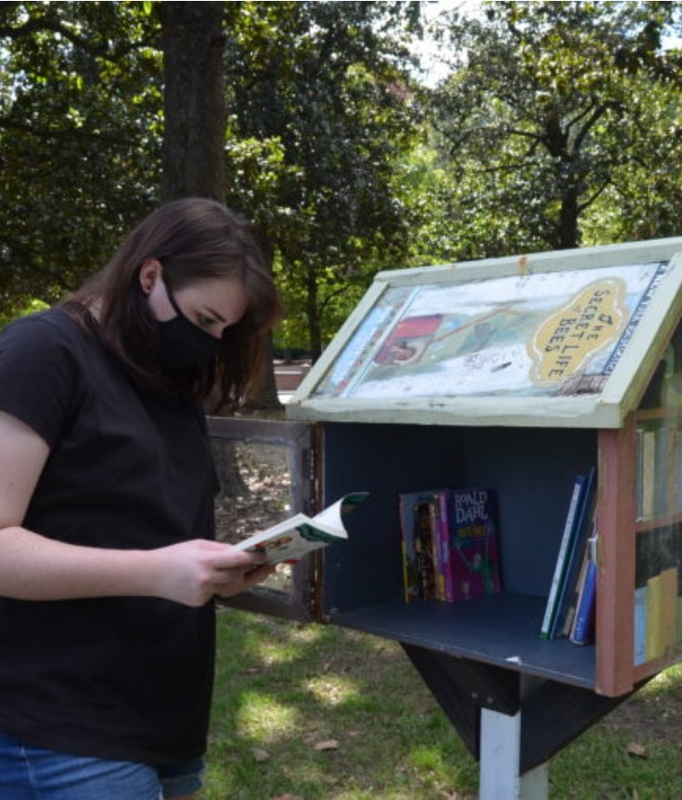 Students check a little free library box