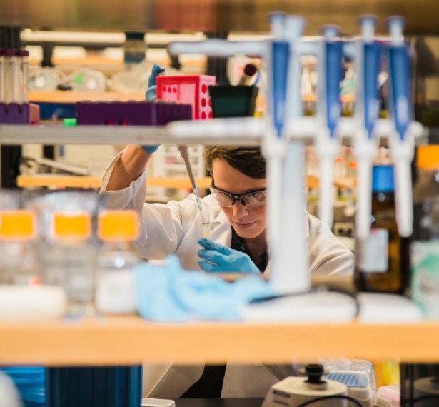 A mercer student mixes chemicals in a lab
