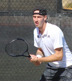 A tennis player holds a racket in position