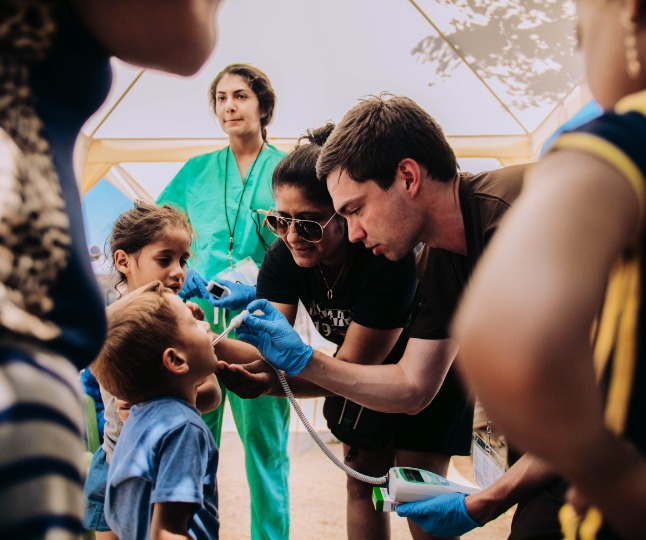 Students take a child's temperature in Greece