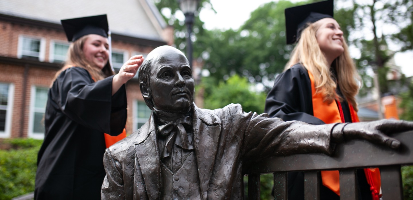 Graduates rub the head of the Jesse Mercer statute on Mercer's Macon campus