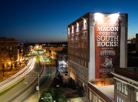 Billboard on a building reads: Welcome to Macon where the South Rocks!