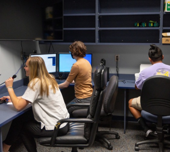 college students sit at computers in a lab