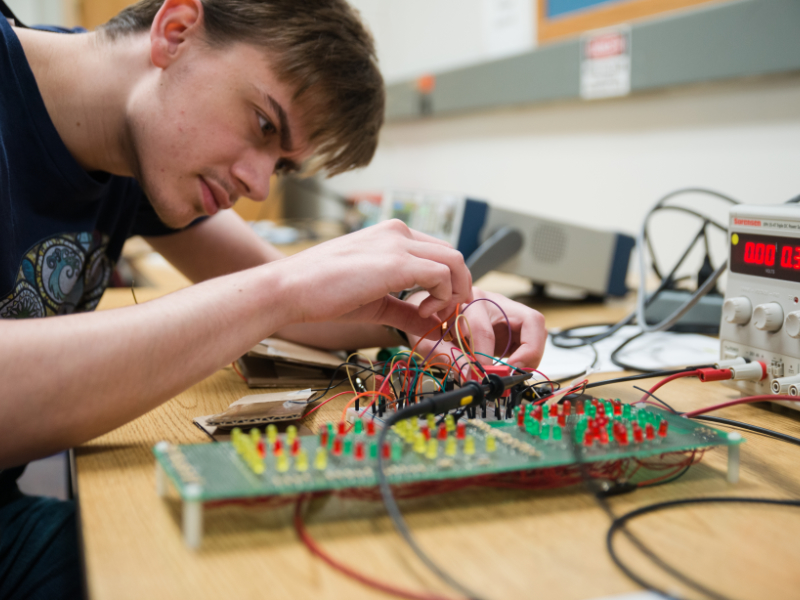 Student works with an electrical board