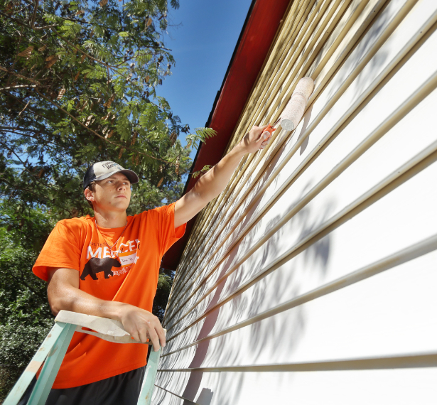 Male painting the exterior of a house