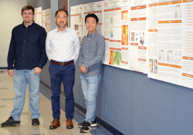 two students stand on either side of dr choi.