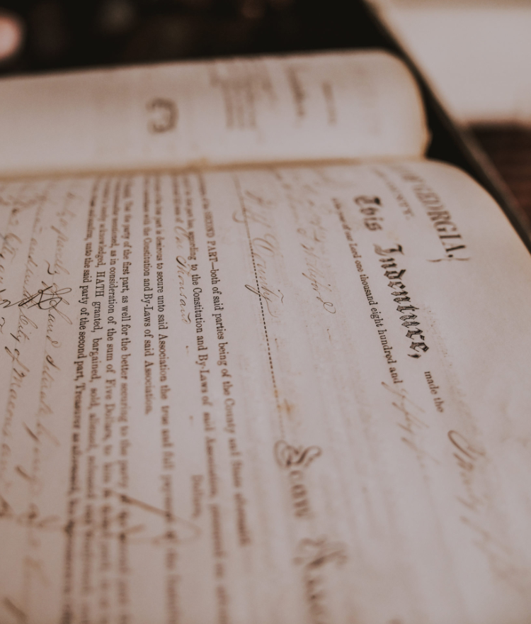 An old deed book lies open. The words
