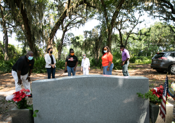 A group from Mercer, including Dr. Melanie Pavich, fourth from left, looks at a grave at Strangers Cemetery on St. Simons Island in August 2021.