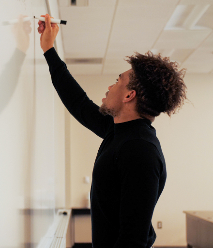 Somtochukwu Obiegbu writes on a white board