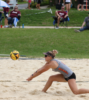 woman leans to hit a volleyball