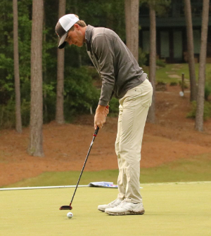 male student putts golf ball