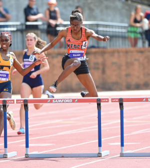 female runner jumps a hurdle