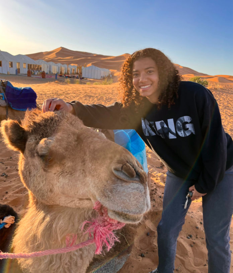 student pets a camel