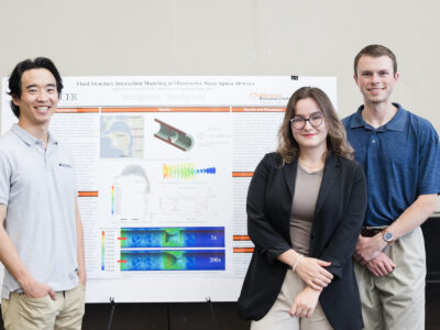 two men and a woman stand in front of a poster titled, "fluid structure interaction modeling of obstructive sleep apnea airways"