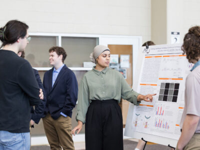 a woman points to a graphic on a poster