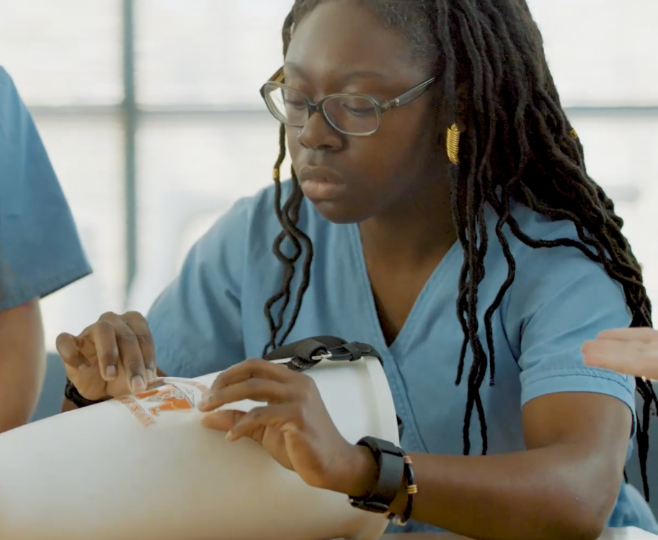 A Mercer University student places a Mercer sticker on a prosthetic leg.