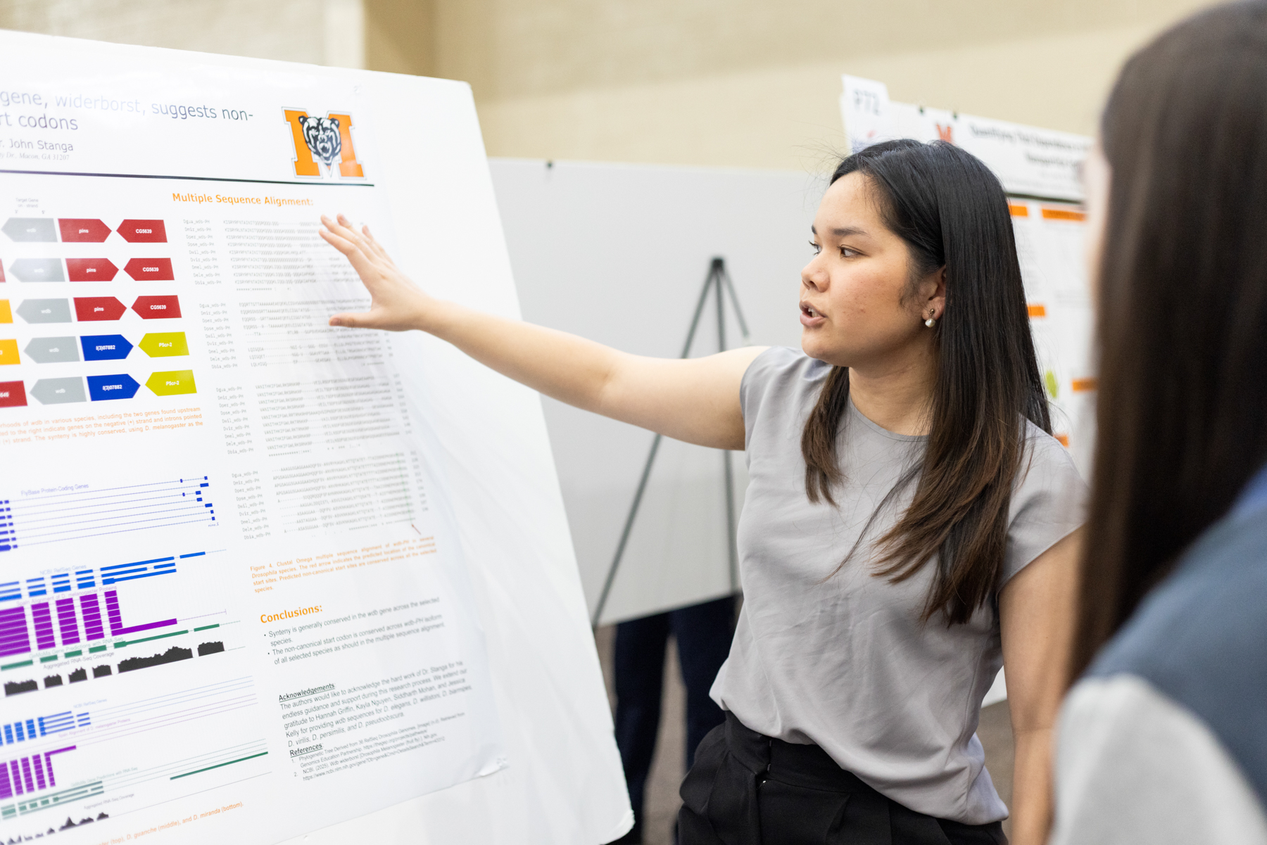 A Mercer University student explains her research poster at BEAR Day.