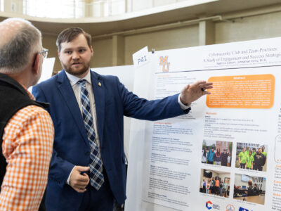 A Mercer University student presents his poster, titled "Cybersecurity Club and Team Practices: A Study of Engagement and Success Strategies," at BEAR Day.