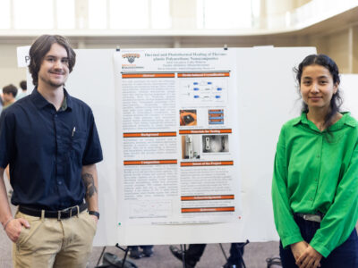 Two Mercer University students stand on either side of their poster, titled "Thermal and Photothermal Healing of Thermo-plastic Polyurethane Nanocomposites," at BEAR Day.