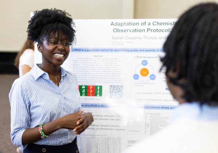 A Mercer student presenting a research poster to another attendee at BEAR Day.