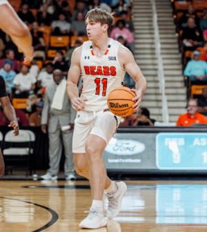Mercer men's basketball player dribbles ball on court.