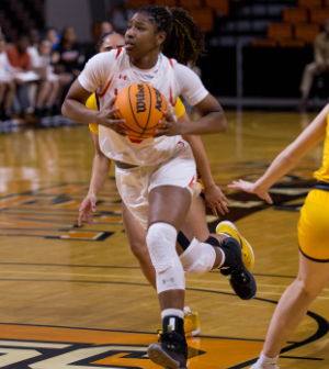 Mercer women's basketball player runs with the ball midgame.
