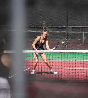 Mercer women's tennis player hits the ball with her racquet during a match.