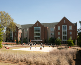 A group of students playing volleyball outside of Legacy Hall