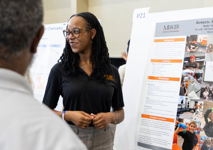 A student presents her poster at BEAR Day.