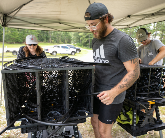 Dr. Adaline Buerck and Mercer graduate student Carter Coursey construct an artificial fish habitat outside.